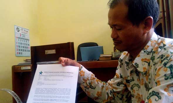 Kepala Kantor Pustasip Rembang Edi Winarno saat menunjukkan lembar undangan palsu dari pihak yang mengaku dari Perpusnas dan hampir saja mengelabuhinya. (Foto: Pujianto)